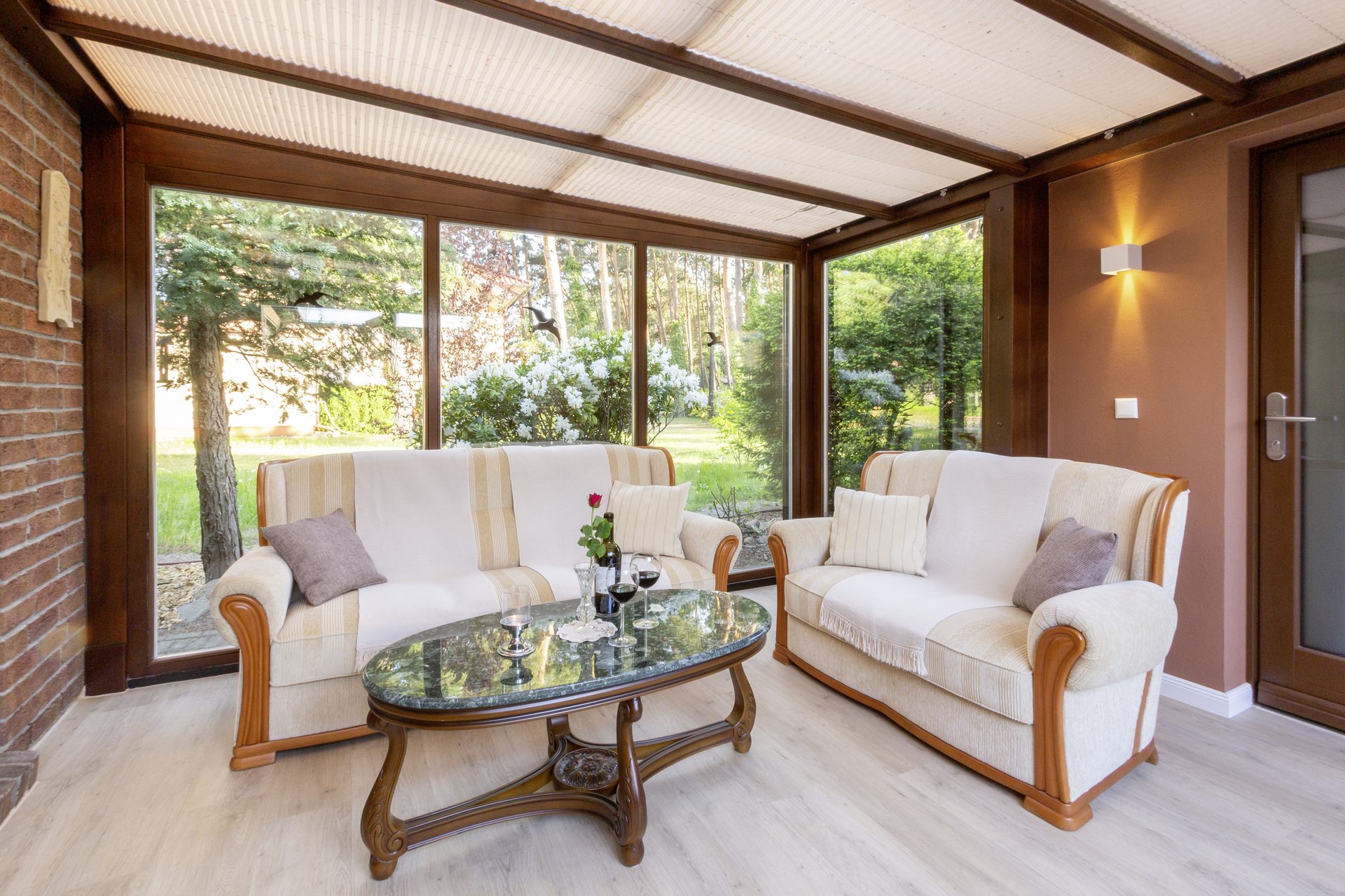 Gemütlicher Wintergarten mit Sofas und Gartenblick